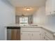 Modern kitchen with stainless steel dishwasher, sink, white countertops, and a bar window at 3610 54Th W St # B4, Bradenton, FL 34209