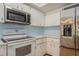 Bright kitchen with white appliances including a microwave and refrigerator with white cabinets at 3610 54Th W St # B4, Bradenton, FL 34209