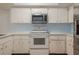 Well-lit kitchen featuring stainless steel appliances, white cabinets, and modern microwave at 3610 54Th W St # B4, Bradenton, FL 34209