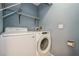 A laundry room featuring a Samsung washer and Whirlpool dryer with overhead metal shelving at 3610 54Th W St # B4, Bradenton, FL 34209
