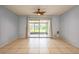 Open-concept living room with tile flooring, ceiling fan, and sliding glass doors to the patio at 3610 54Th W St # B4, Bradenton, FL 34209