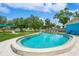 Community pool with blue lounge chairs surrounded by lush landscaping and blue sky at 3610 54Th W St # B4, Bradenton, FL 34209
