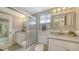 Well-lit bathroom featuring dual vanities, granite countertops, and a glass enclosed shower/tub at 3647 Lake Bayshore Dr # 416, Bradenton, FL 34205