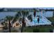 View of a community pool and clubhouse next to a waterfront with mature palm trees at 3647 Lake Bayshore Dr # 416, Bradenton, FL 34205