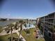 An elevated view overlooking a beautiful community pool with lake views and tropical landscaping at 3647 Lake Bayshore Dr # 416, Bradenton, FL 34205
