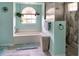 Well-lit bathroom with a tub, shower, decorative tile, and hanging plants at 3984 Holin Ln, North Port, FL 34287