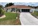 Charming single-story home with well-manicured lawn, decorative landscaping, and long driveway at 3984 Holin Ln, North Port, FL 34287