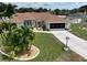 Well-maintained home features beautiful landscaping, lush lawn, and long driveway at 3984 Holin Ln, North Port, FL 34287