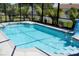 Sparkling screened pool features a fountain, Baja bench and convenient access steps at 3984 Holin Ln, North Port, FL 34287