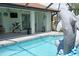 Relaxing pool area features a dolphin fountain, covered patio, and tropical decor at 3984 Holin Ln, North Port, FL 34287