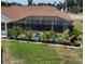 The screen lanai surrounds the home's pool and is surrounded by lush landscaping at 3984 Holin Ln, North Port, FL 34287