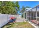 Home exterior displaying a white fence and a boat rack holding a kayak, with access to the screened-in patio at 425 46Th Nw St, Bradenton, FL 34209