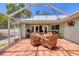 Enclosed patio featuring tile flooring, a dining table, and multiple wicker chairs, perfect for outdoor entertainment at 425 46Th Nw St, Bradenton, FL 34209