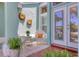 Cozy front patio area with wicker furniture and decorative sunflower wall decor and plant life at 425 46Th Nw St, Bradenton, FL 34209