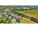 Aerial view of homes in a community with mature trees and landscaping; note the red arrow indicating the subject property at 4740 105Th E Ave, Parrish, FL 34219