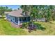 Exterior of home boasting a screened-in porch and expansive yard shaded by a mature tree at 4740 105Th E Ave, Parrish, FL 34219