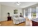 Inviting bedroom with wood floors, neutral walls, ceiling fan, and natural light from large windows at 4740 105Th E Ave, Parrish, FL 34219