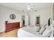Cozy bedroom with wood floors, neutral walls, a decorative clock, and ample natural light from large windows at 4740 105Th E Ave, Parrish, FL 34219