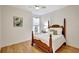 Bright bedroom featuring a ceiling fan, wood-look floors, natural light, and a charming four-poster bed at 4740 105Th E Ave, Parrish, FL 34219