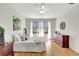 Bright bedroom featuring wood floors, neutral walls, ceiling fan, and natural light from two windows at 4740 105Th E Ave, Parrish, FL 34219