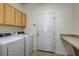 Well-lit laundry room featuring modern appliances, upper cabinets, countertop and convenient access to the house at 4740 105Th E Ave, Parrish, FL 34219