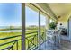Inviting balcony featuring green railing with table, chairs, plantings and waterviews in the distance at 4801 Osprey S Dr # 405, St Petersburg, FL 33711