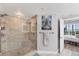 Modern bathroom showing walk-in shower with glass door, stone flooring and corner seating at 4801 Osprey S Dr # 405, St Petersburg, FL 33711