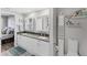 Bright bathroom featuring double sinks, granite countertop, updated cabinets, decor and decorative shelving unit at 4801 Osprey S Dr # 405, St Petersburg, FL 33711