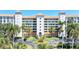 Beautiful condo building with manicured grounds, palm trees, and a circular driveway, showcasing luxury living at 4801 Osprey S Dr # 405, St Petersburg, FL 33711