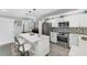 Well-lit kitchen boasts white cabinets, stainless steel appliances, and a central island with seating and stylish pendants at 4801 Osprey S Dr # 405, St Petersburg, FL 33711