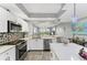Modern kitchen features stainless steel appliances, white cabinets, and a center island with a marble countertop at 4801 Osprey S Dr # 405, St Petersburg, FL 33711