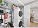 Efficient laundry area with stacked washer and dryer, complemented by organized shelving and storage at 4801 Osprey S Dr # 405, St Petersburg, FL 33711
