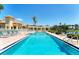 Community pool surrounded by lounge chairs, palm trees, and lush landscaping next to a lake at 4801 Osprey S Dr # 405, St Petersburg, FL 33711