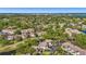 Aerial view highlighting the community buildings and beautiful landscaping with mature trees and a serene lake at 5291 Willow Links # 54, Sarasota, FL 34235