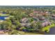 Aerial view showcasing community buildings near a golf course, mature trees, and lush landscaping at 5291 Willow Links # 54, Sarasota, FL 34235