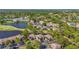 Aerial view of the community showcasing lush landscaping, multiple buildings, and a beautiful lake at 5291 Willow Links # 54, Sarasota, FL 34235