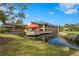 A view of the complex on a sunny day with lush green grass and lake at 5291 Willow Links # 54, Sarasota, FL 34235