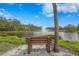 Picturesque view of a pond with a fountain, framed by a bench and lush greenery at 5291 Willow Links # 54, Sarasota, FL 34235
