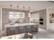 Modern kitchen featuring a large island with seating, designer pendant lighting, and stainless steel appliances at 555 Quay Cmn # 804, Sarasota, FL 34236