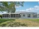 Lush backyard featuring a screened lanai and views of the serene lake at 5596 Sabal Trace Dr, North Port, FL 34287