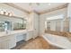 Luxurious bathroom with dual sinks, a soaking tub, and ample storage at 5596 Sabal Trace Dr, North Port, FL 34287