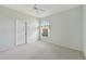 A serene bedroom with a large window, neutral carpet, and a ceiling fan for added comfort at 5596 Sabal Trace Dr, North Port, FL 34287