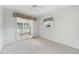 Airy bedroom with soft carpet, a sliding glass door to a patio, and pleasant backyard views at 5596 Sabal Trace Dr, North Port, FL 34287