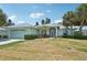 Charming single-story home featuring a well-manicured lawn, a two-car garage, and lush tropical landscaping at 5596 Sabal Trace Dr, North Port, FL 34287