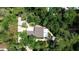 Aerial view of home surrounded by mature trees and tropical landscaping at 590 Artists Ave, Englewood, FL 34223