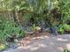 Backyard seating area with chairs, flower pot, and landscaped backyard at 590 Artists Ave, Englewood, FL 34223