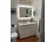 Bathroom vanity features an illuminated mirror, mosaic backsplash, and modern fixtures at 590 Artists Ave, Englewood, FL 34223