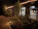 Nighttime view of home exterior, showcasing the brick walkway, garden plants, and soft lighting illuminating the facade at 590 Artists Ave, Englewood, FL 34223