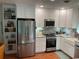 Bright kitchen featuring white cabinets, stainless steel appliances, and granite countertops at 590 Artists Ave, Englewood, FL 34223