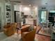 Bright kitchen featuring stainless steel appliances, white cabinets, and comfortable seating area with unique chairs at 590 Artists Ave, Englewood, FL 34223